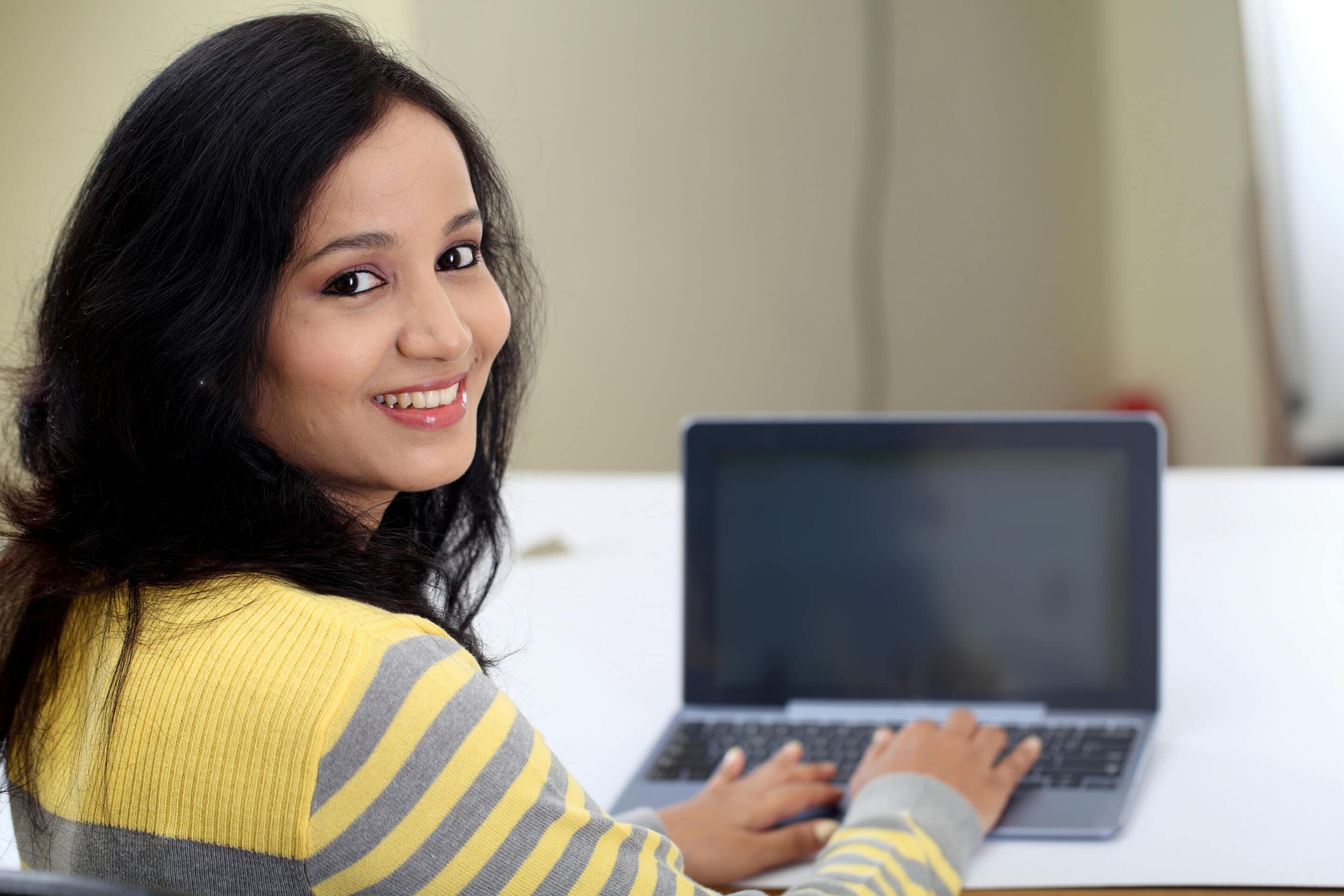 Girl smiling by computer